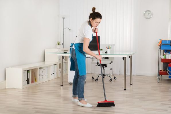 Female Janitor Sweeping Floor With Broom